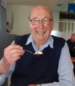Elderly man eating at a table